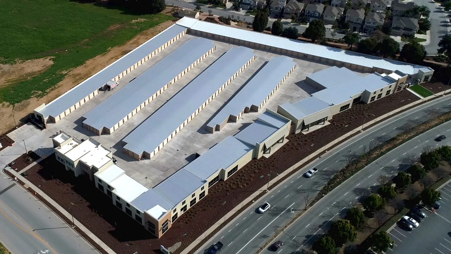 Daytime aerial of Butterfield Self Storage's parallel unit rows and office beside the road