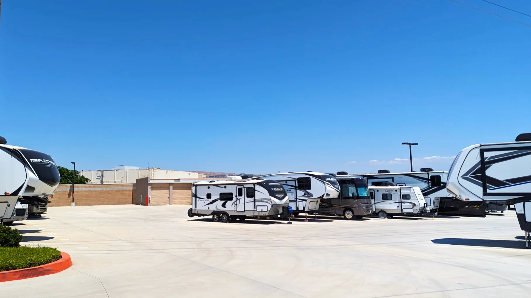 Fifth-wheels, travel trailers and a motorhome in the RV and boat spaces at Gilroy Self Storage