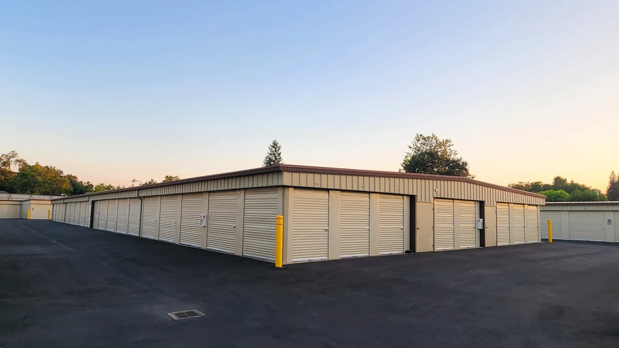 Corner of a long drive-up unit building at Placer Self Storage in evening light