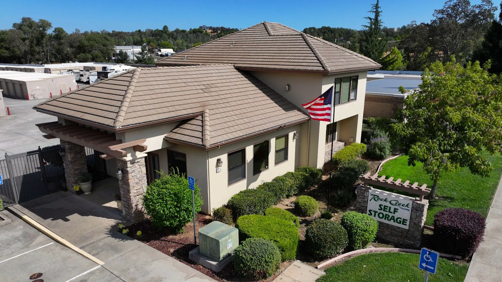 The tile-roofed rental office at Rock Creek Self Storage, with its monument sign and flagpole