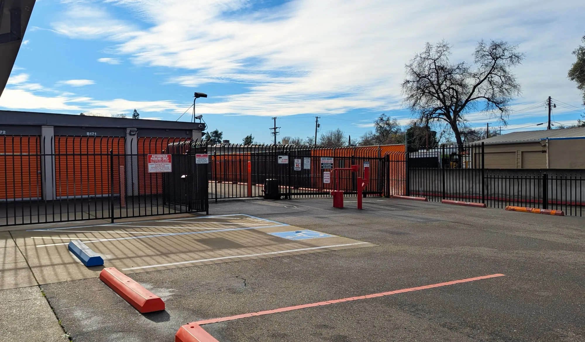 The gated entrance at Armor Self Storage in Sacramento, CA, with keypad and posted gate hours